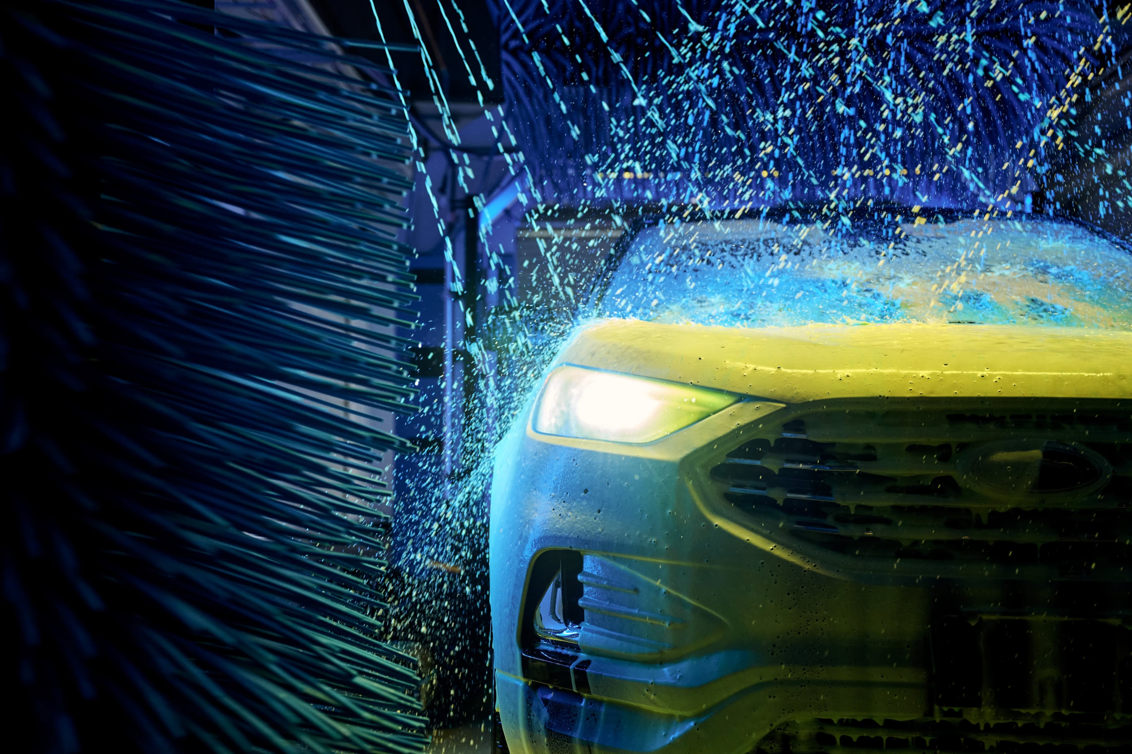 Car in an automated car wash with blue and yellow lights