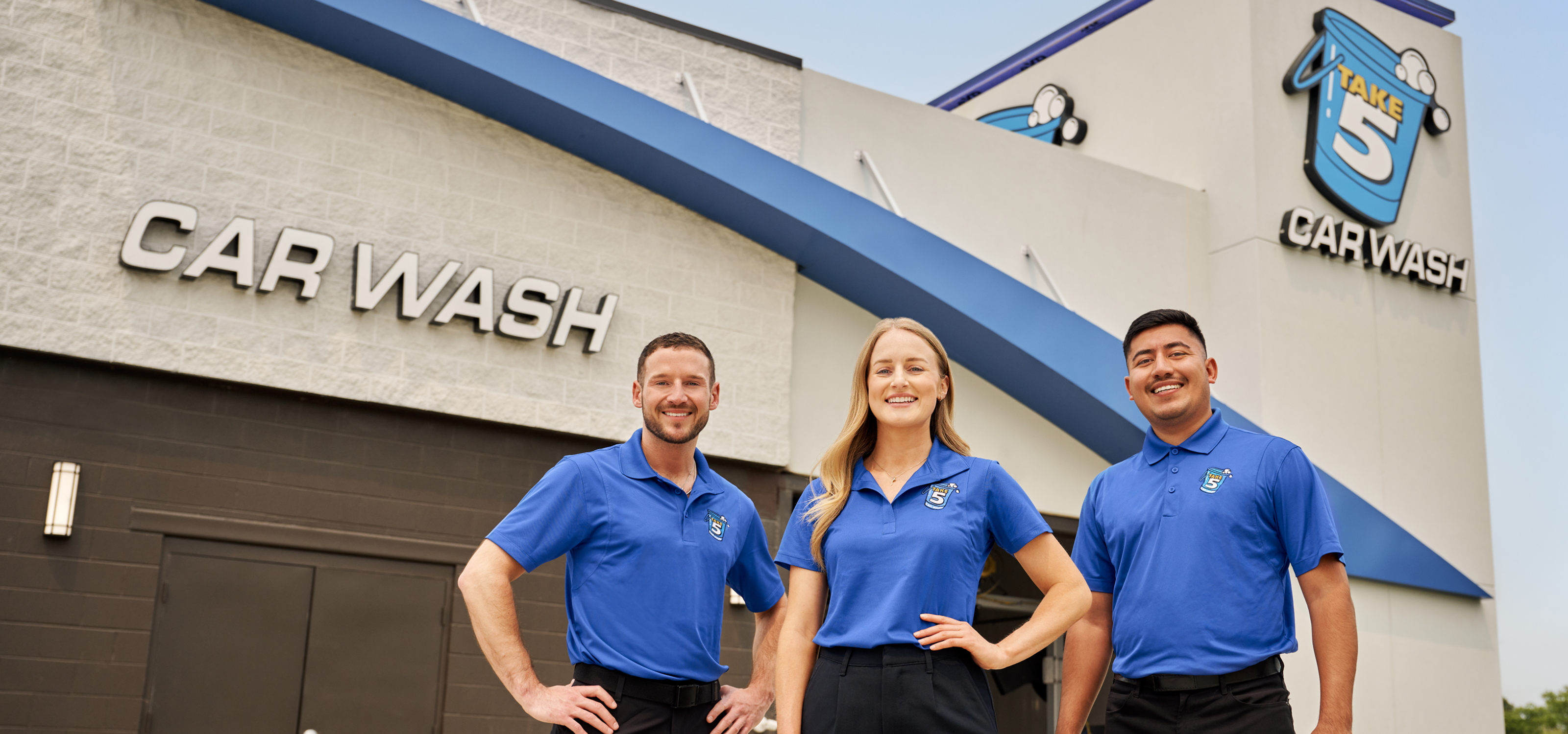 Happy Take 5 Car Wash employees standing in front of the building.